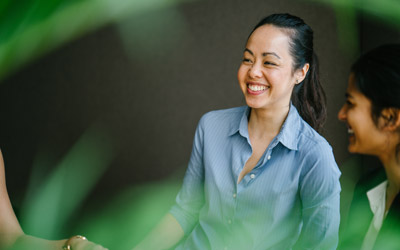 Female laughing with plant blurred in foreground